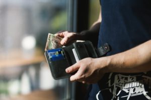 Foto von einer Person die Geld zahlt um zu verdeutlichen, dass der Immobilien-Eigentümer bei einer Sonderumlage noch einmal extra Geld zahlen muss. Eine Zahlung die der Immobilien-Eigentümer aus eigener Tasche zahlen muss.